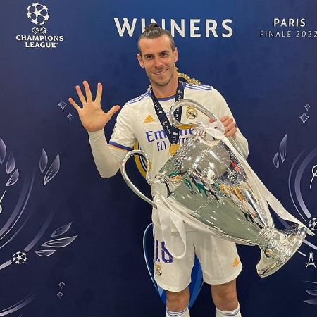 Alba Violet Bale's father, Gareth Bale holding the UEFA cup in his hand and showing five fingers indicating five goals in the final match. Bale wearing white jersey of the football club Real Madrid.